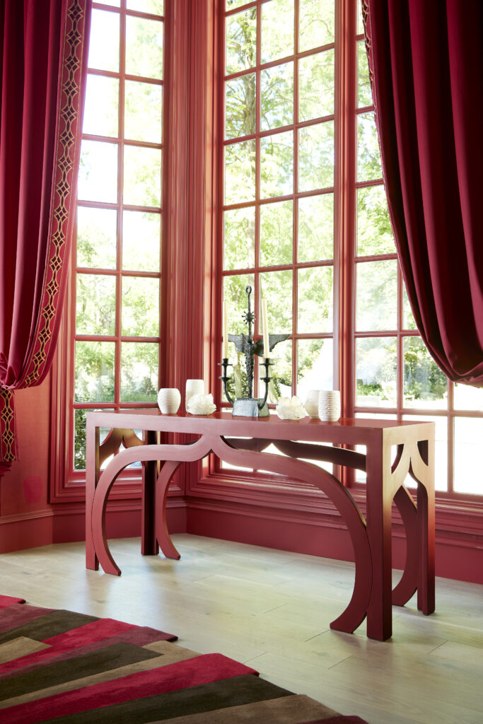 a bright red console sits in front of a window.