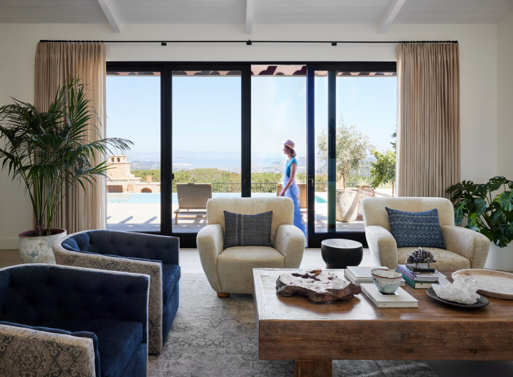 A living room opens out to a beautiful outdoor beach scene. 