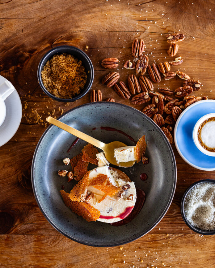butter pecan semifreddo served in a deep steel bowl with a spoon.