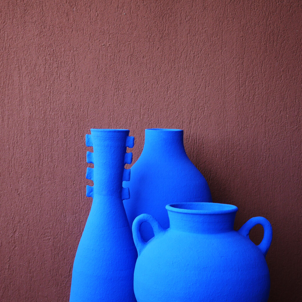 Three vases in various blue pigmented shapes against a burgundy background featured at the Maison&Objet Show.