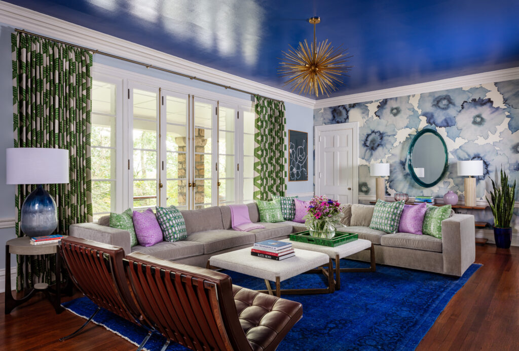 A living room with a bright blue colored floor and reflective ceiling. A pale couch sits in the corner.