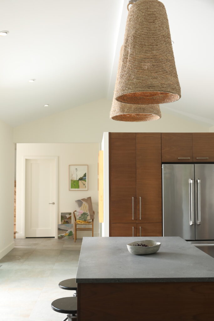 The kitchen of a Chautauqua Lake House with a dark counter top with brown lights over top.