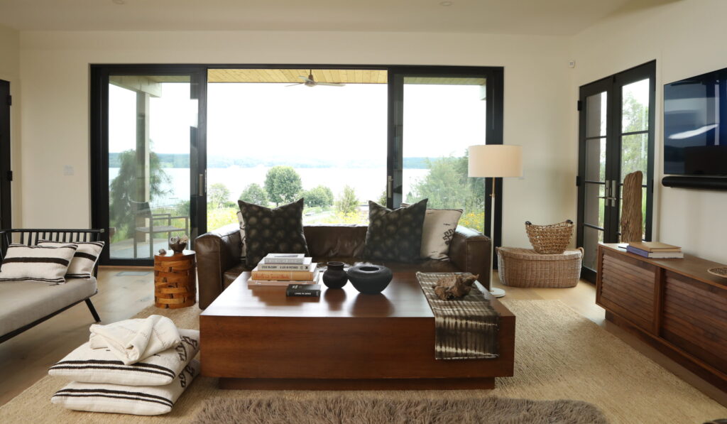 The living room of a Chautauqua lake house with a wood coffee table, modern couch and beige walls.