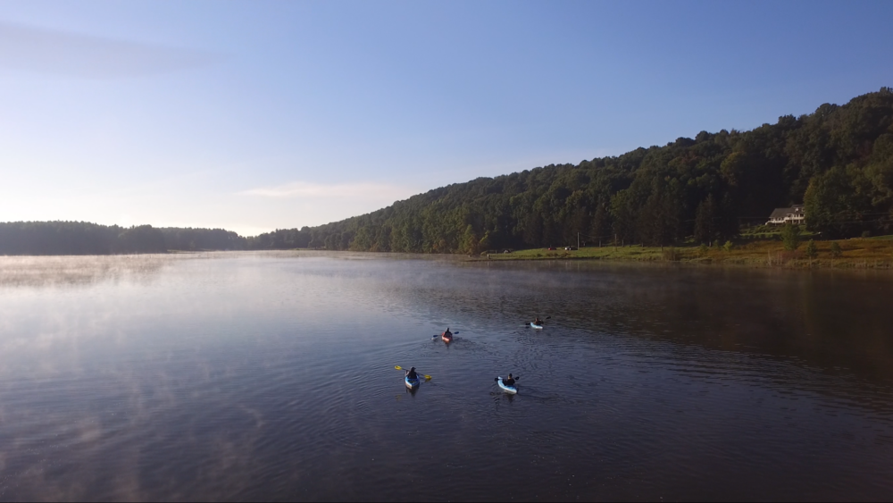 A vast picturesque look at the lake in Crawford County with several canoes in the water.