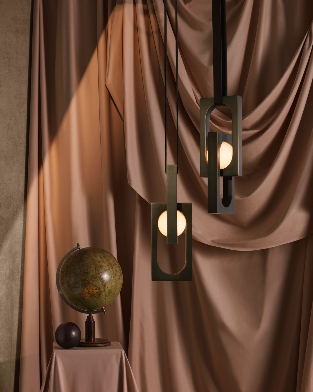 Lee Broom's lights MYTHOS against a curtain backdrop. 