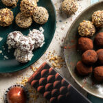 Two plates of mocha truffles coated in cocoa powder and nuts with nespresso pods and chocolate bars nearby.