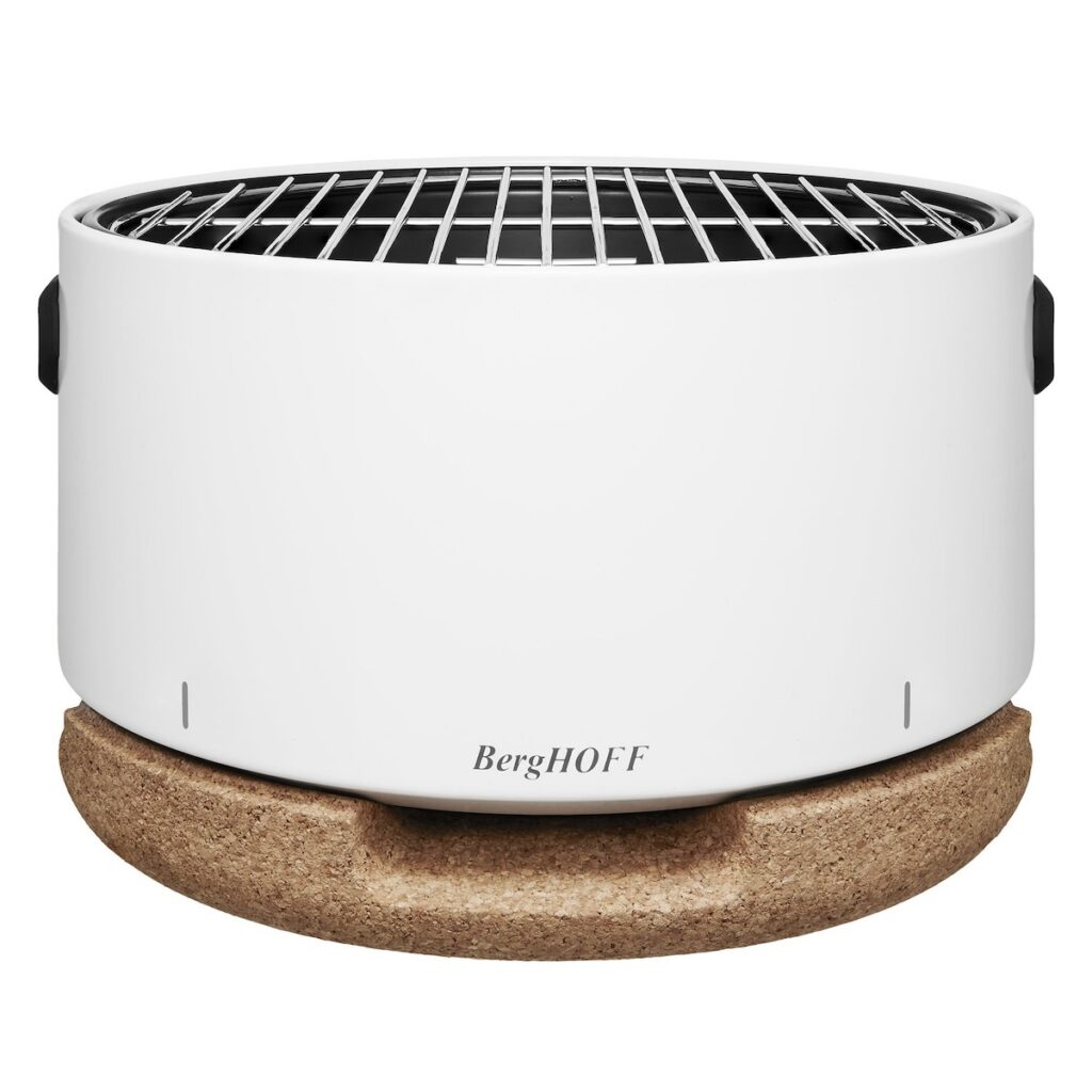 A white travel grill with a wood bottom base sits on a white background.