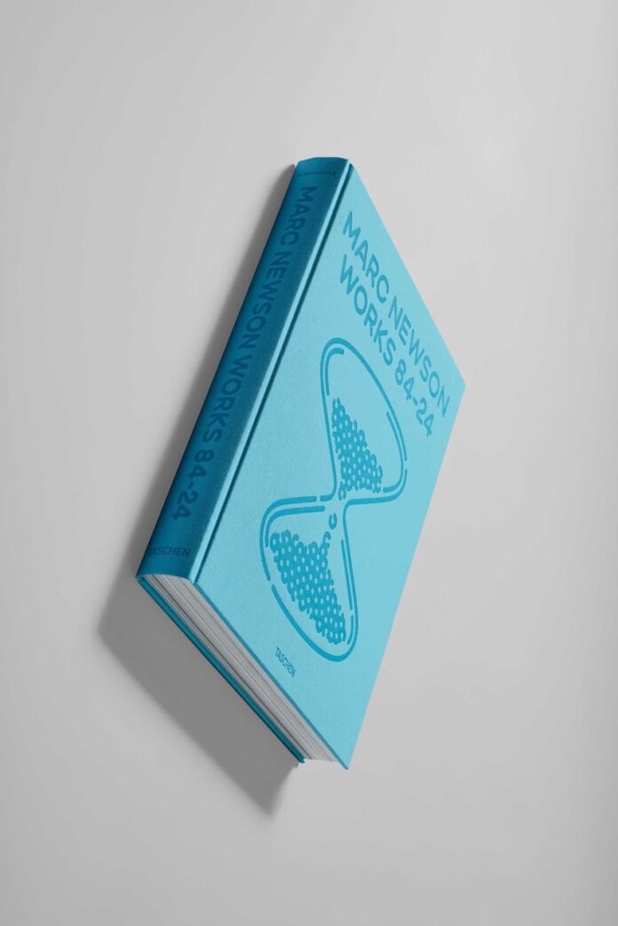 Marc Newson Works Book TABLE Magazine The cover of Marc Newson Works: 84-24 sits face up showing a blue cover with a dark blue hourglass.