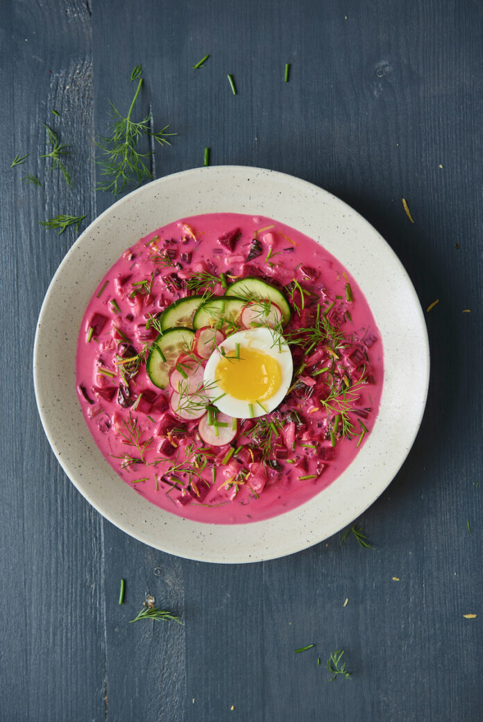 TABLE Magazine Cold Beet Soup A bowl of pink soup staged over a black background