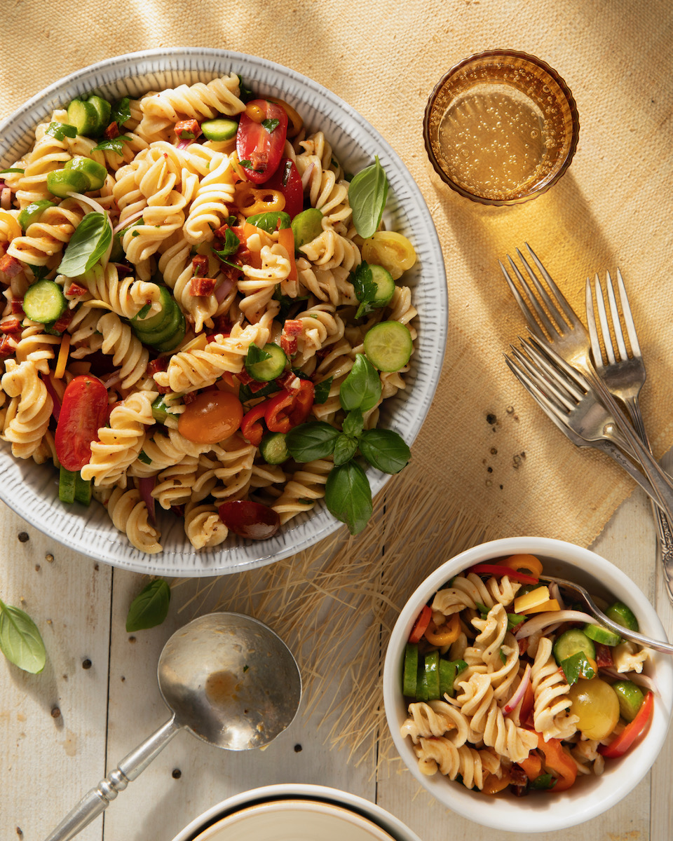 A summer pasta salad using local ingredients on a white background