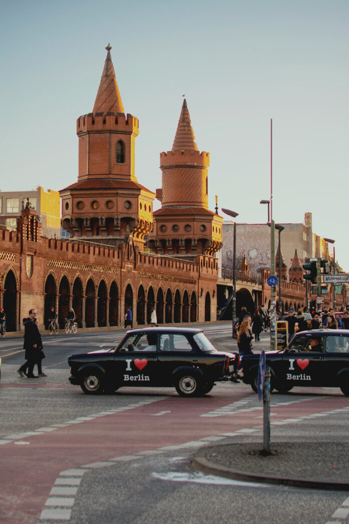 A street corner in Berlin with a black cab reading I