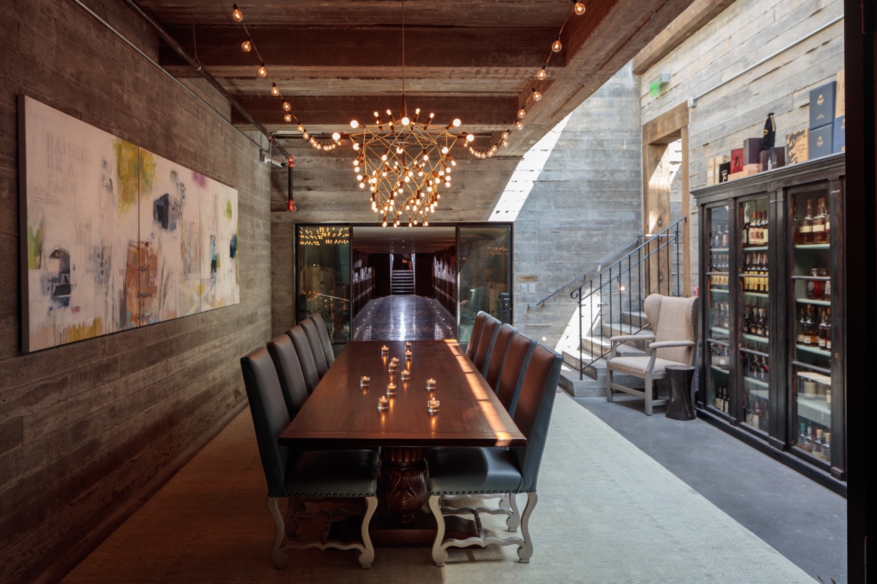 A long table sits inside a half dimly lit and half bright space amongst Blackberry Farm.
