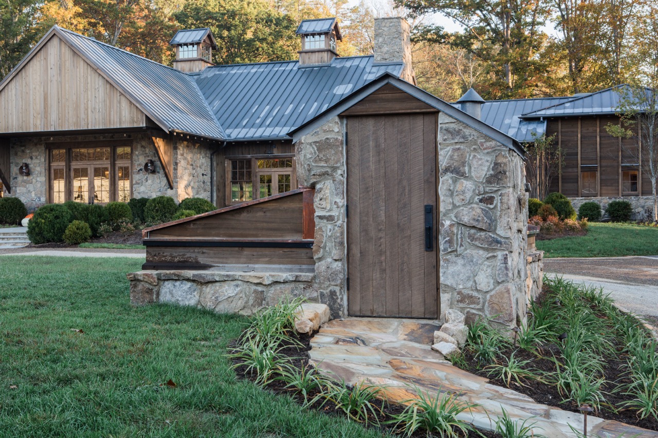 The outside of Blackberry Farm sits a stone and wood building amongst the trees.