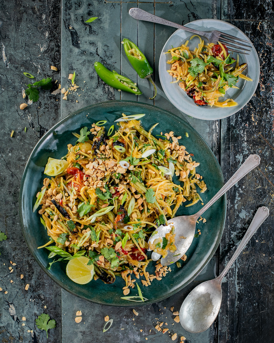 Papaya salad made in a woodfire oven on a black background