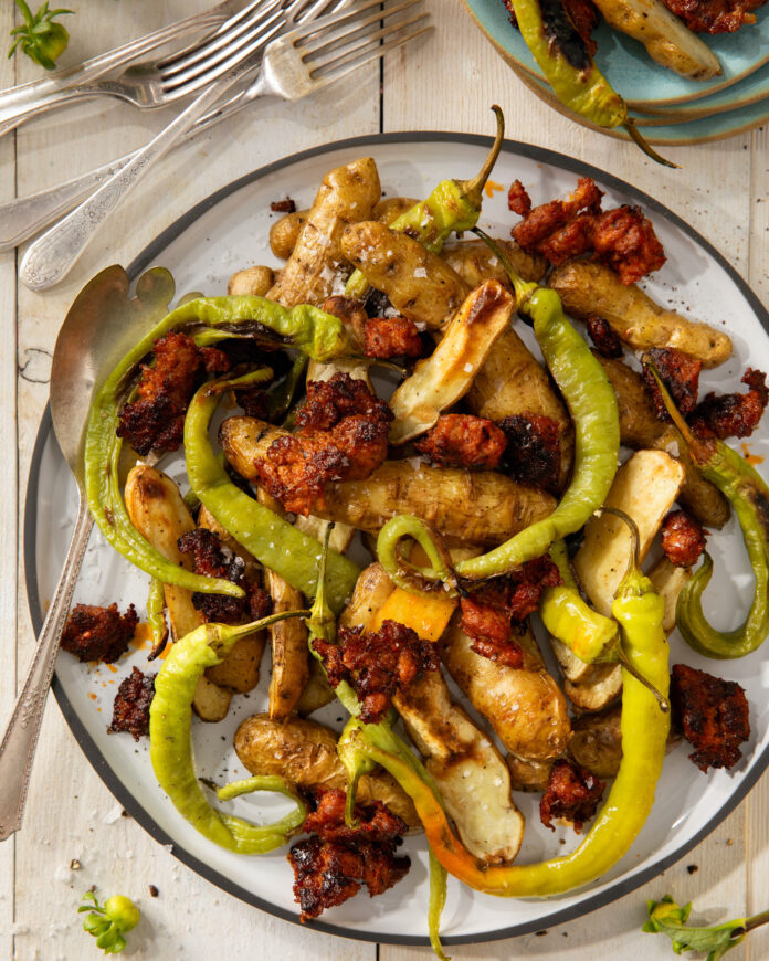 A plate of ozettes, Corbaci peppers, and sausage on a white background