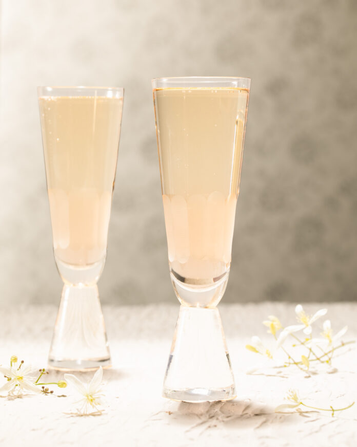 A champagne cocktail inspired by Emily in Paris on a white background
