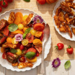 A plate of cherry tomatoes and fried cheese curds, topped with flowers