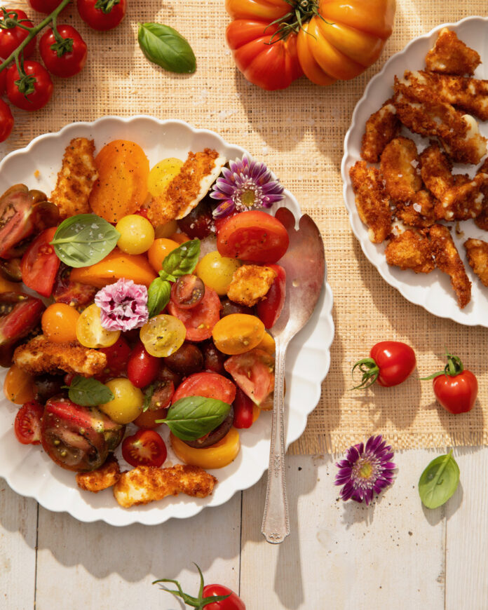 A plate of cherry tomatoes and fried cheese curds, topped with flowers