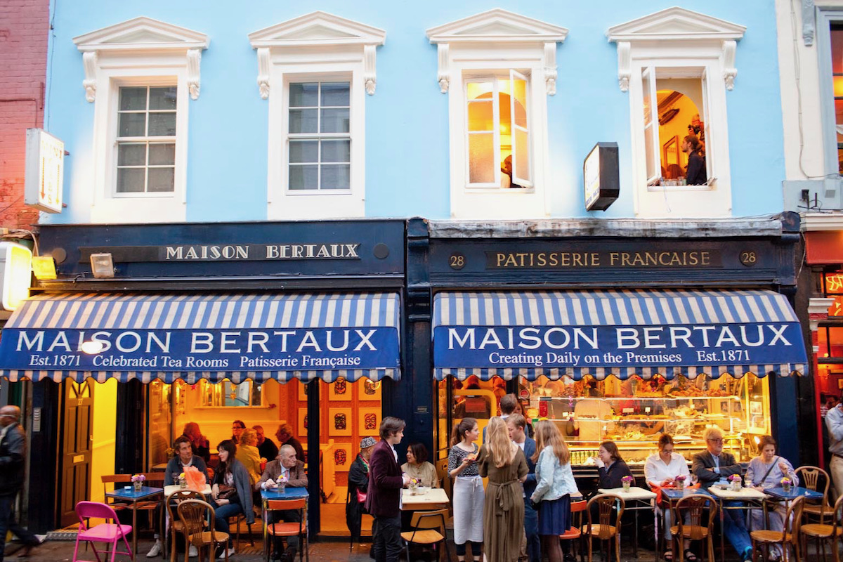 The façade of Maison Bertraux in London, with a blue striped awning