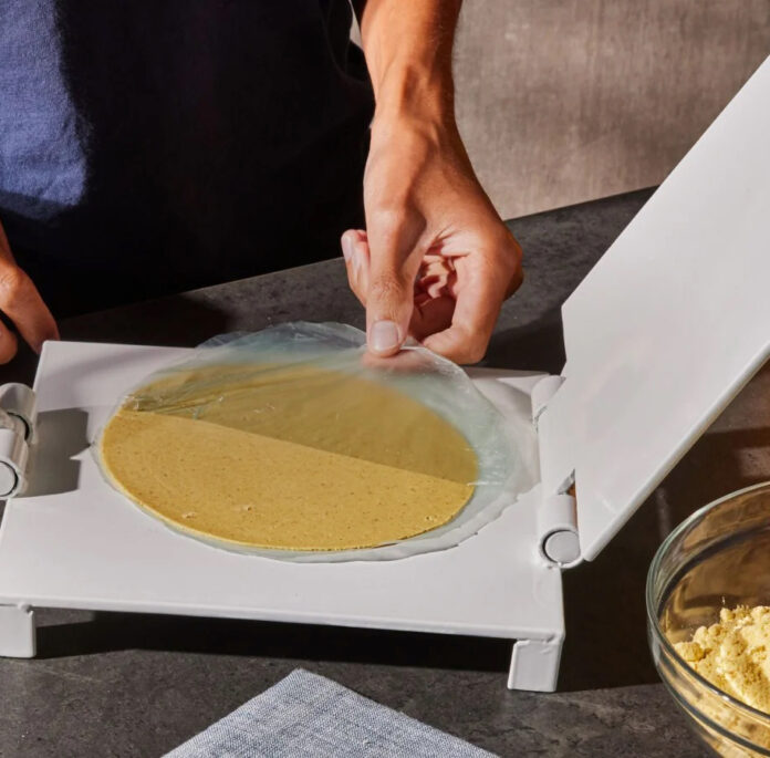 A chef cooks a tortilla using Masienda's tortilla press
