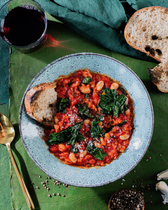 A Stanley Tucci inspired beans and greens recipe on a bright green background