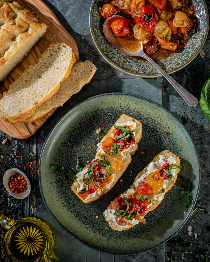 Charred tomato toast with focaccia on a black background