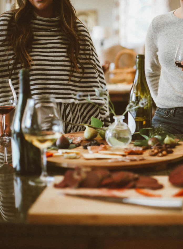 Two women enjoy a weeknight dinner of charcuterie and wine