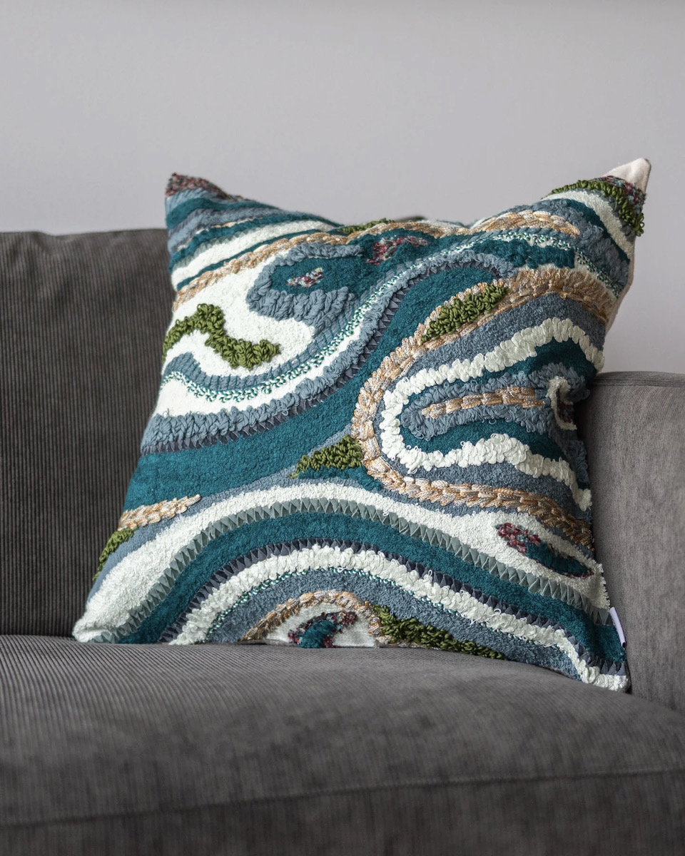 A green and white pillow with a swirl pattern 