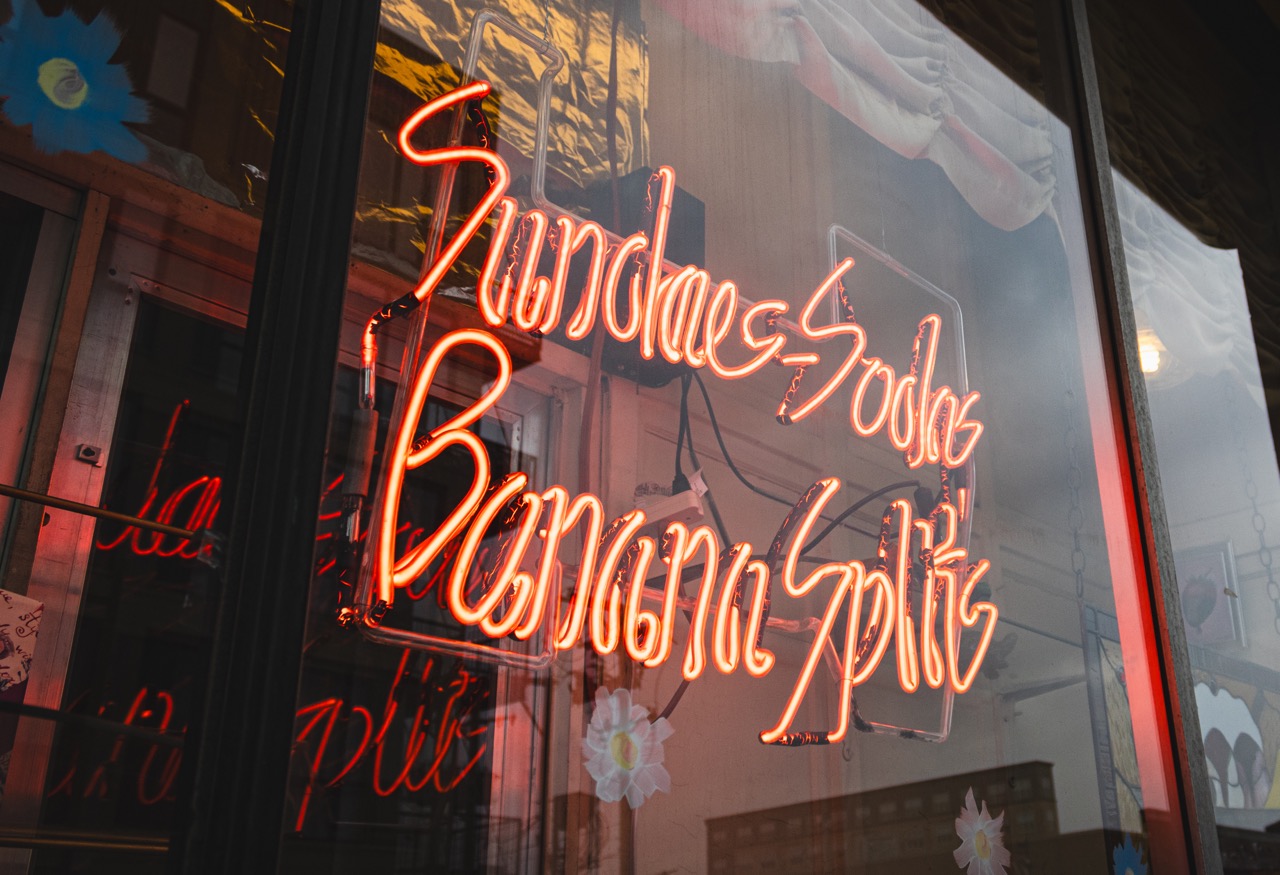 A red neon sign reads "sundaes, sodas, banana splits" at Margie's Candies in Chicago. 