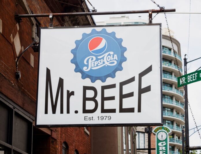 The Mr. Beef sign hands beside a Mr.Beef street sign.