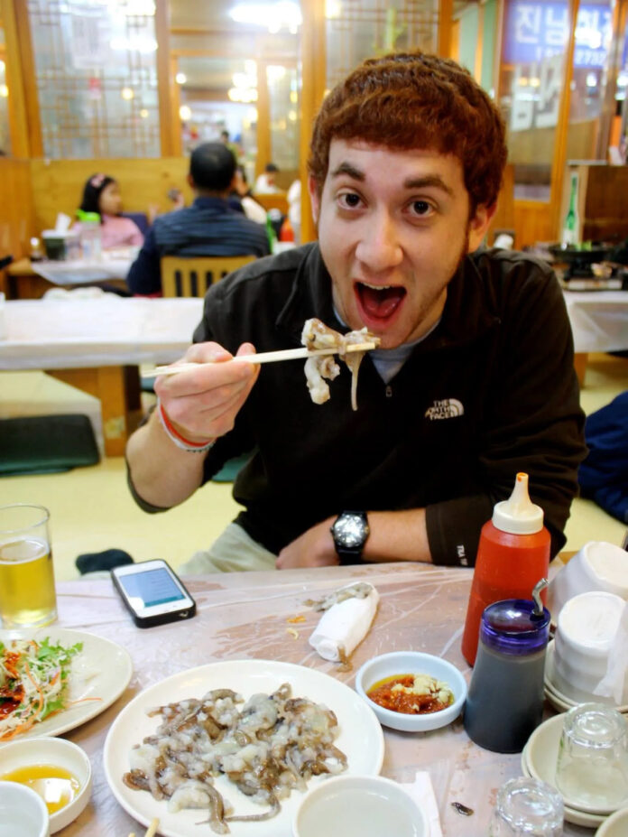 YouTuber Drew Binsky enjoys a plate of noodles