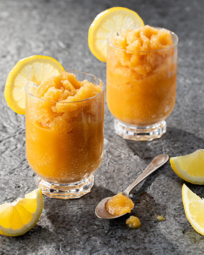 A pair of bourbon slush cocktails on a grey background