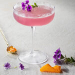 A gin and jam cocktail on a white background