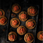 A plate of Halloween cookies on a black background
