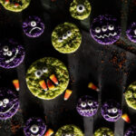 A set of monster rice krispy treat Halloween dessert cookies with candy eyes and candy corn on them