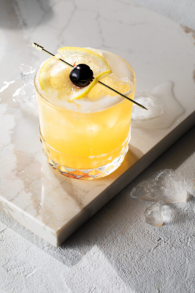 A whiskey sour on a white background