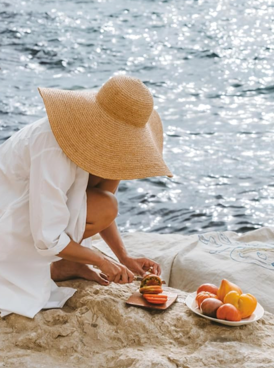 A woman beside the Mediterranean sea eats oranges off a plate