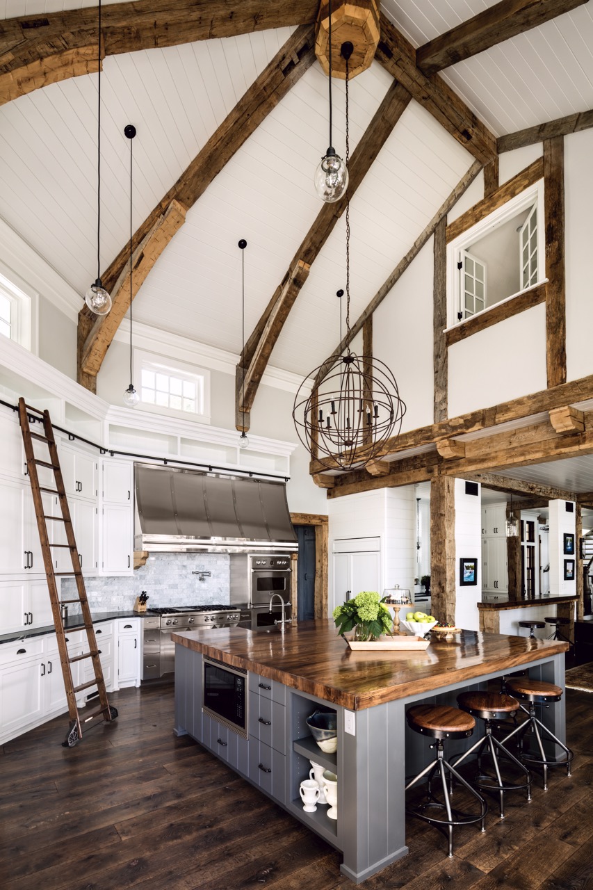 A Wade Weissmann designed kitchen includes wooden highlights like a ladder and countertop and white cabinets and walls otherwise. 