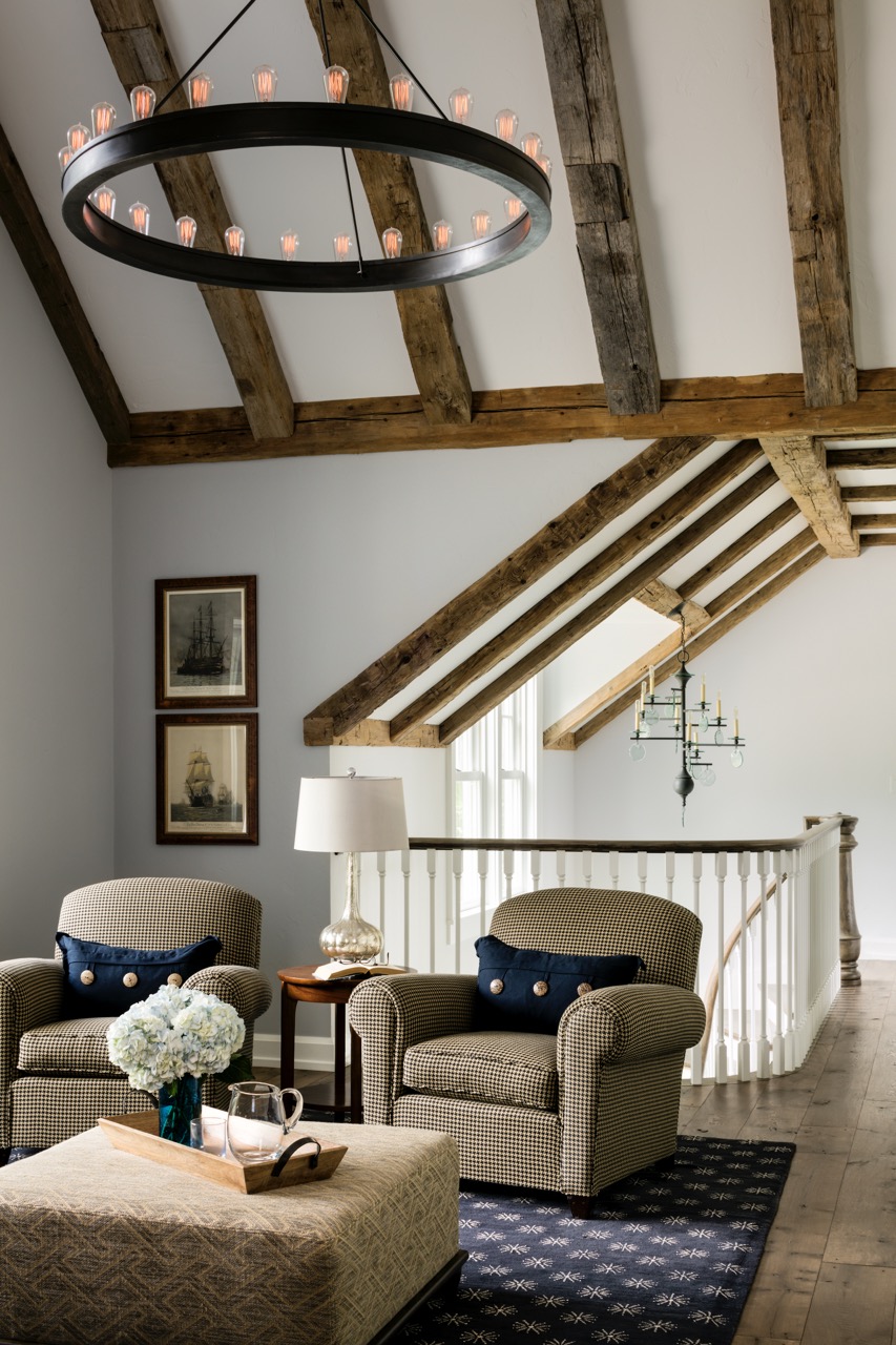 An upstairs loft area with two brown armchairs and wood accents on the ceiling. 