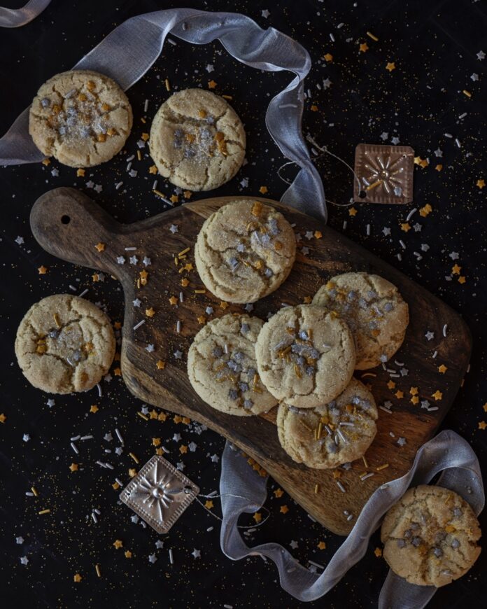Crackly Sugar Cookies A group of Crackly Sugar Cookies sit on a brown sitting board with festive decorations around them.