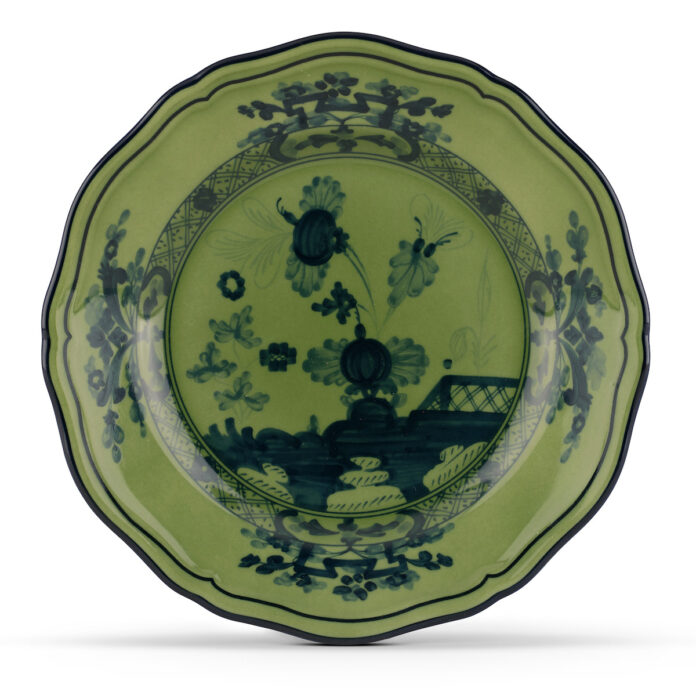 A green plate with glaze embossing on it