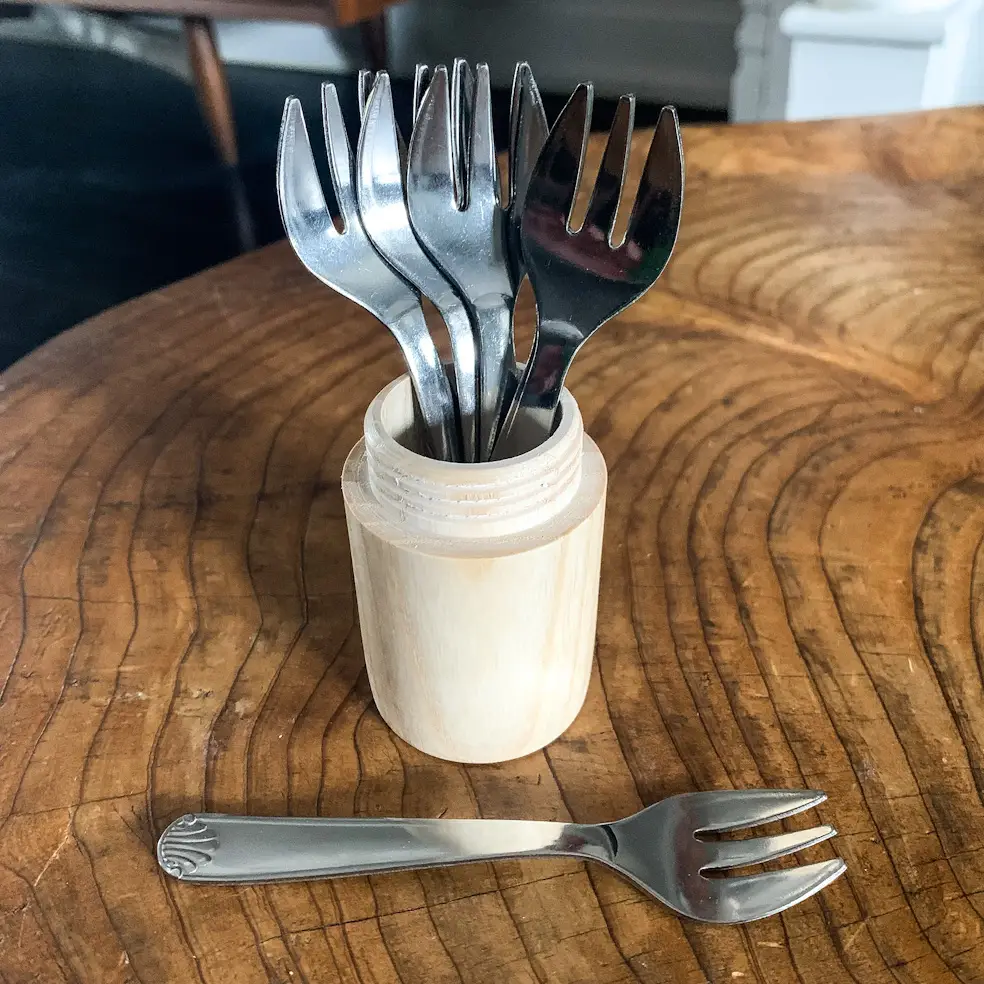 Five oyster forks on a table 