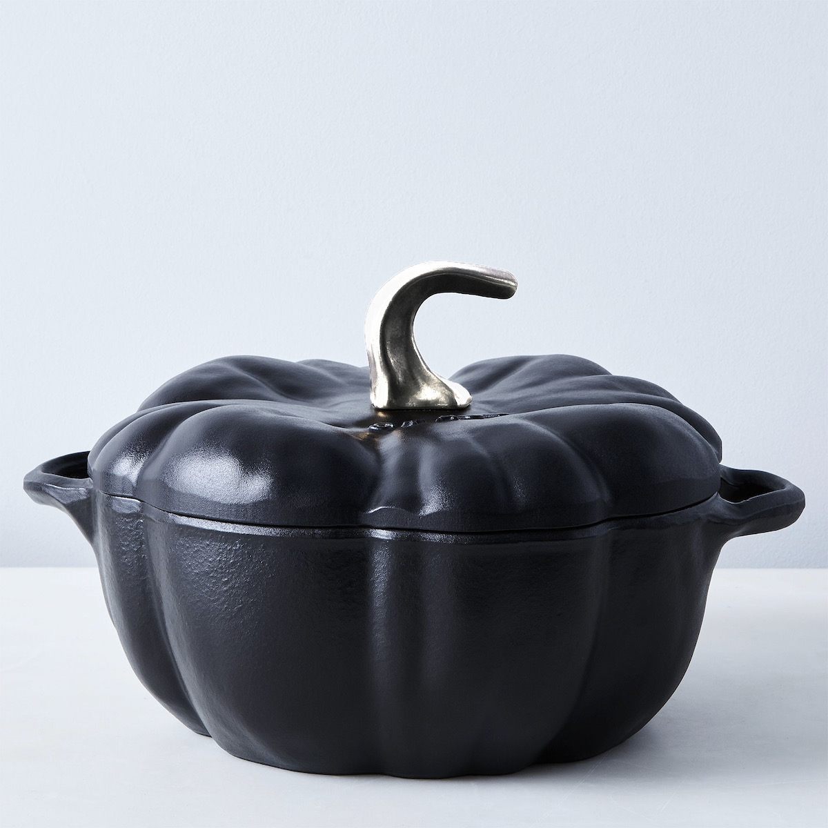 A black crockpot shaped like a pumpkin