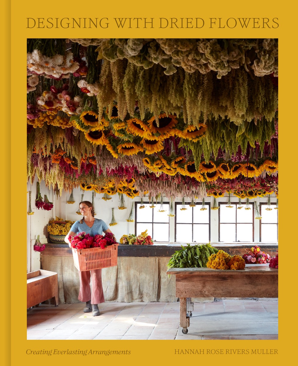 The cover of Designing with Flowers, featuring a woman walking underneath a ceiling of beautiful flowers 