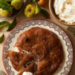 Apple Tarte Tatin with Homemade Puff Pastry served on a plate along side a plate of butter and apples