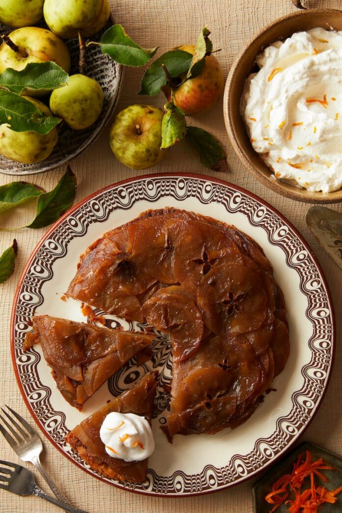 Apple Tarte Tatin with Homemade Puff Pastry served on a plate along side a plate of butter and apples