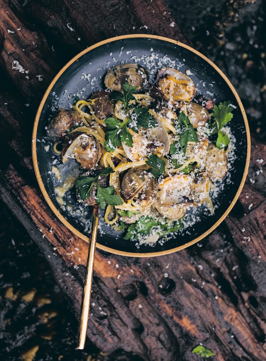 A pan of smoked clam carbonara with a sprinkling of cheese