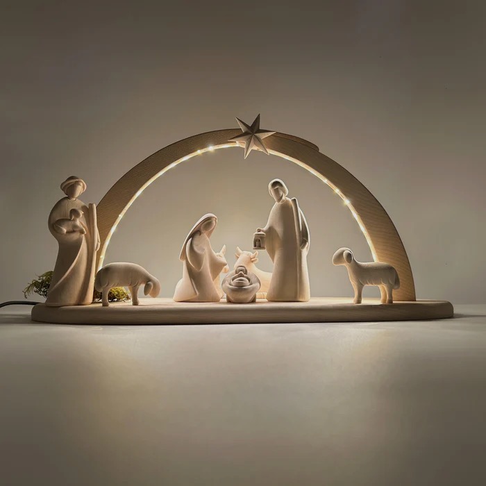 A white nativity scene lit from the back, with the figures underneath an arch topped with a star