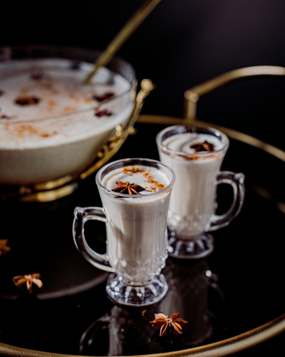A set of coquito cocktails on a black bavkground 