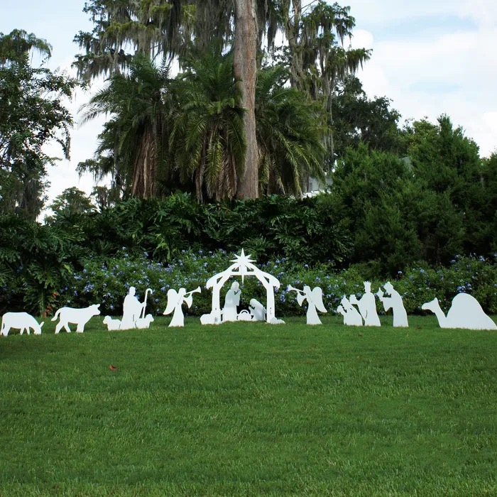 An outdoor nativity scene on a sunny day in a green field